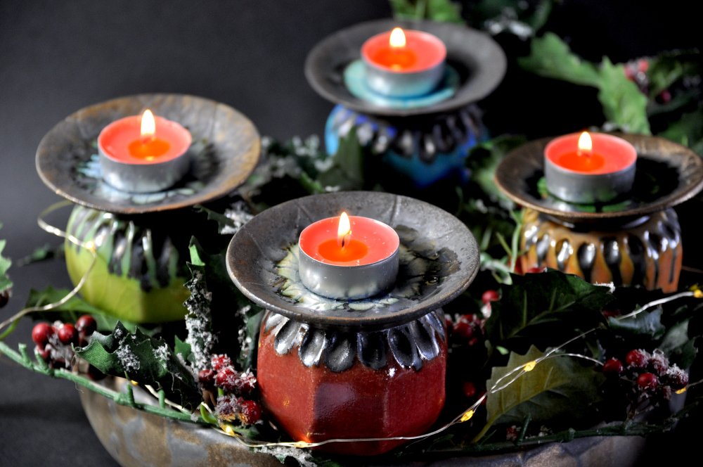 Ceramic poppy seed heads as part of a Christmas wreath with tealight candles on top