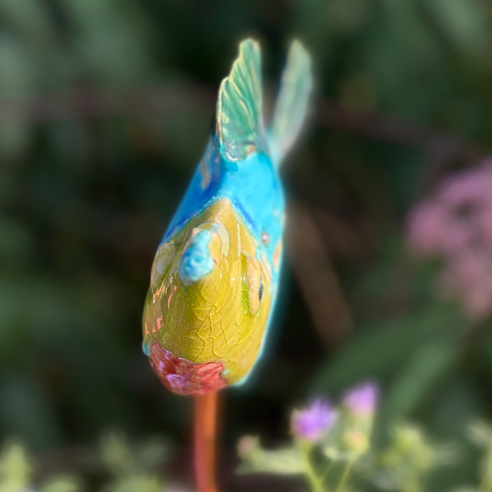 Tropical fish "Paul", glazed in bright colours, sitting on a copper rod