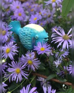 ceramic fish in flower bed