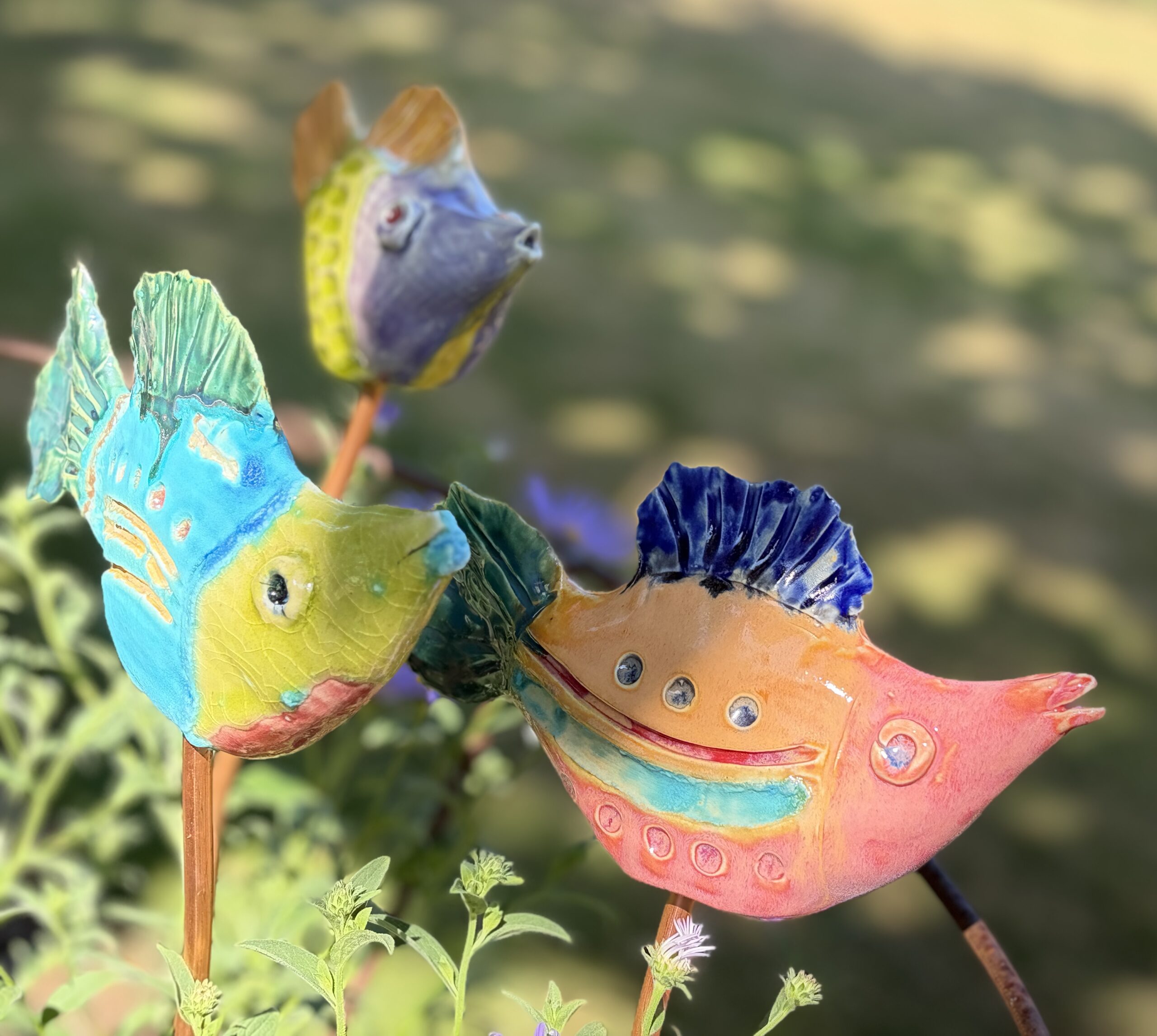 a group of ceramic fish glazed in tropical colours