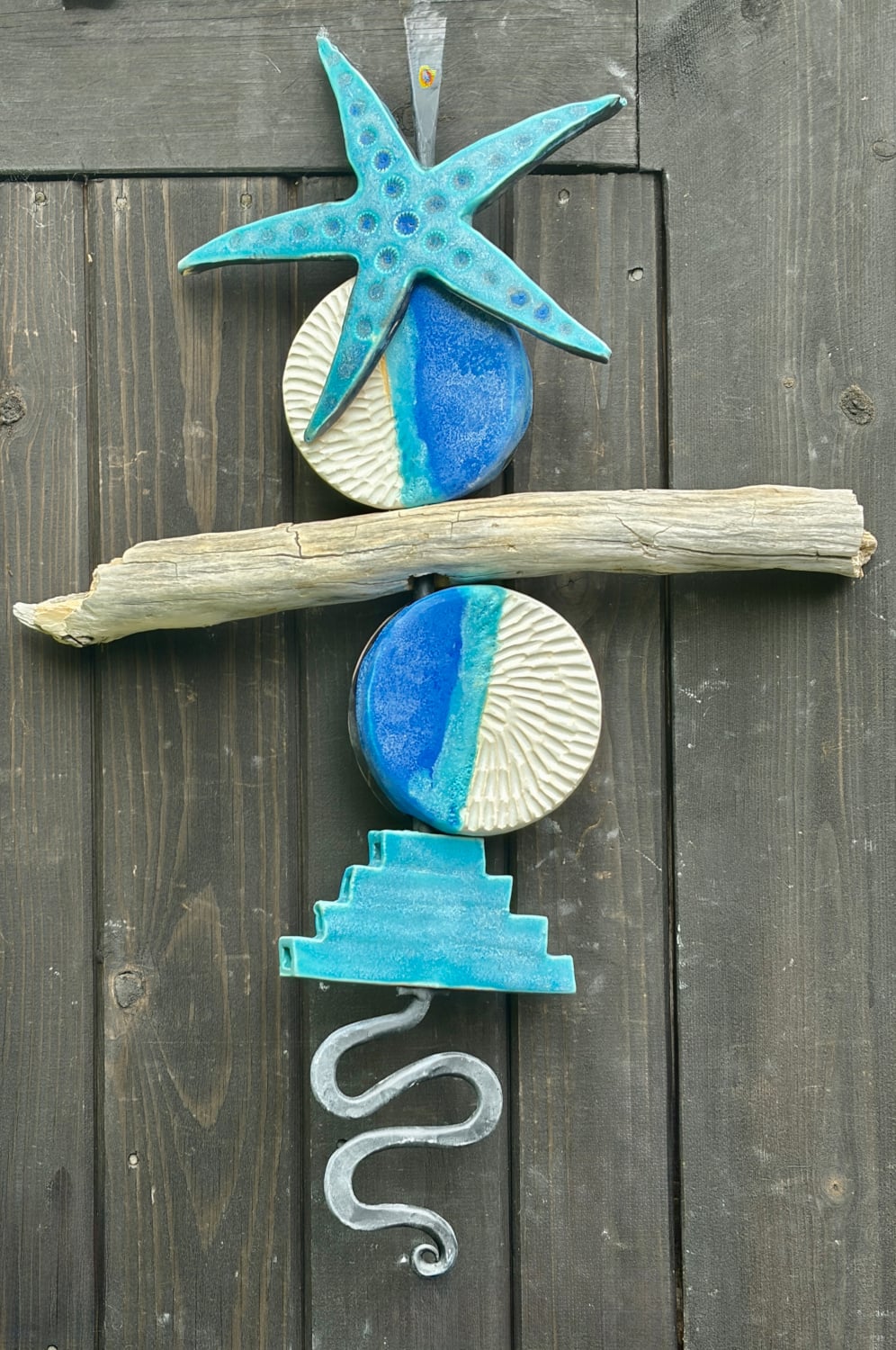 Tideline with large ceramic starfish, ceramic elements and driftwood