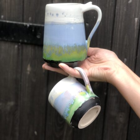 Tsmall and large mug in Horizon design, glazed in pastel range of glazes from dark-green to lime-green and light-blue, topped by satin white
