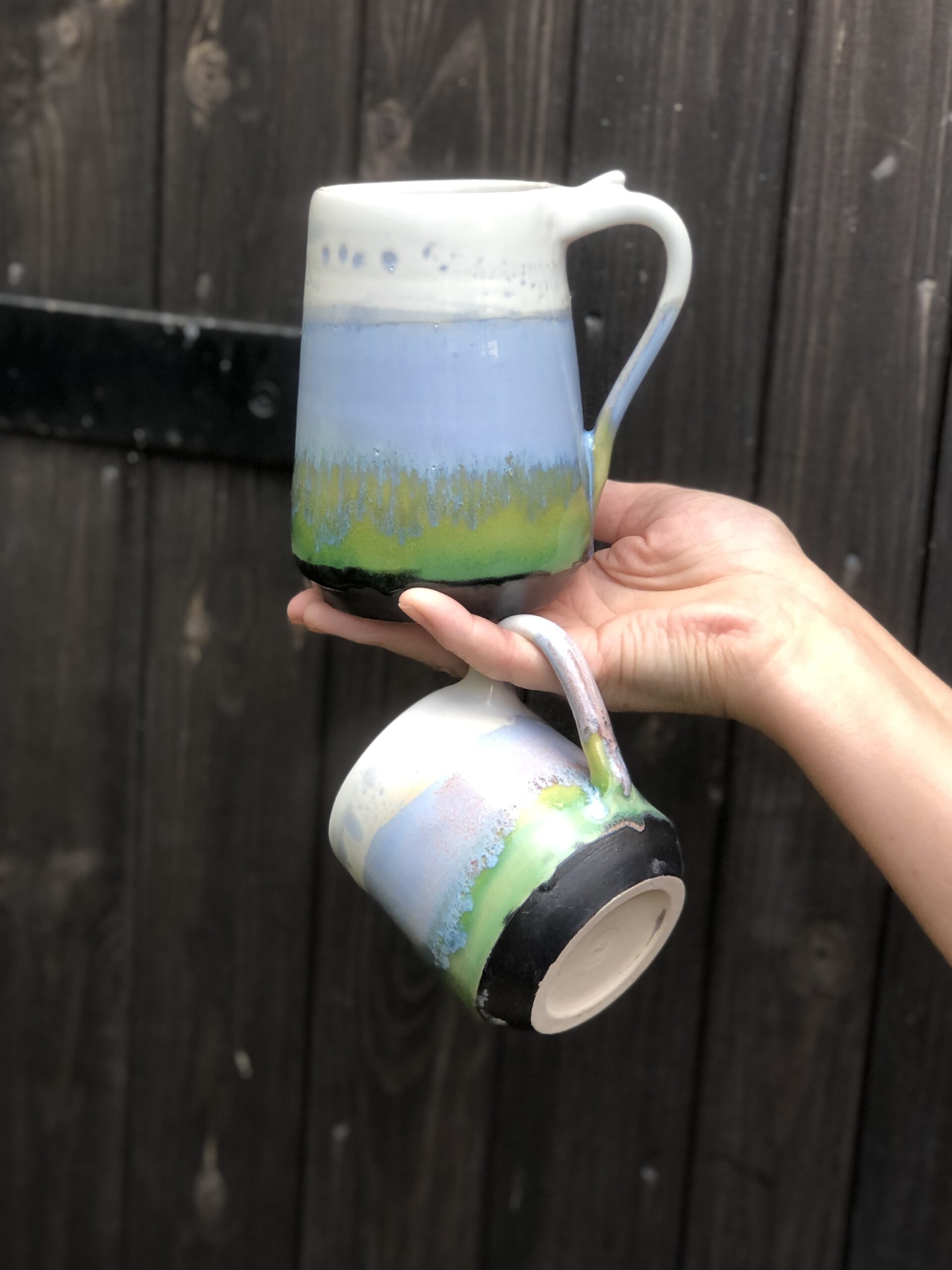 Tsmall and large mug in Horizon design, glazed in pastel range of glazes from dark-green to lime-green and light-blue, topped by satin white