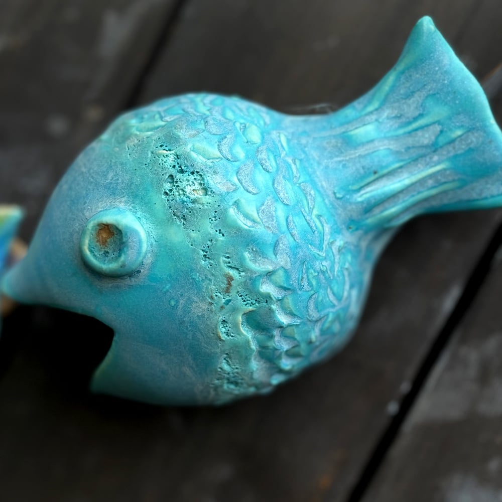 Blue fish as part of the fish-catcher; Wall hanging art: 5 ceramic fish assembled on a metal hoop with decorative scroll