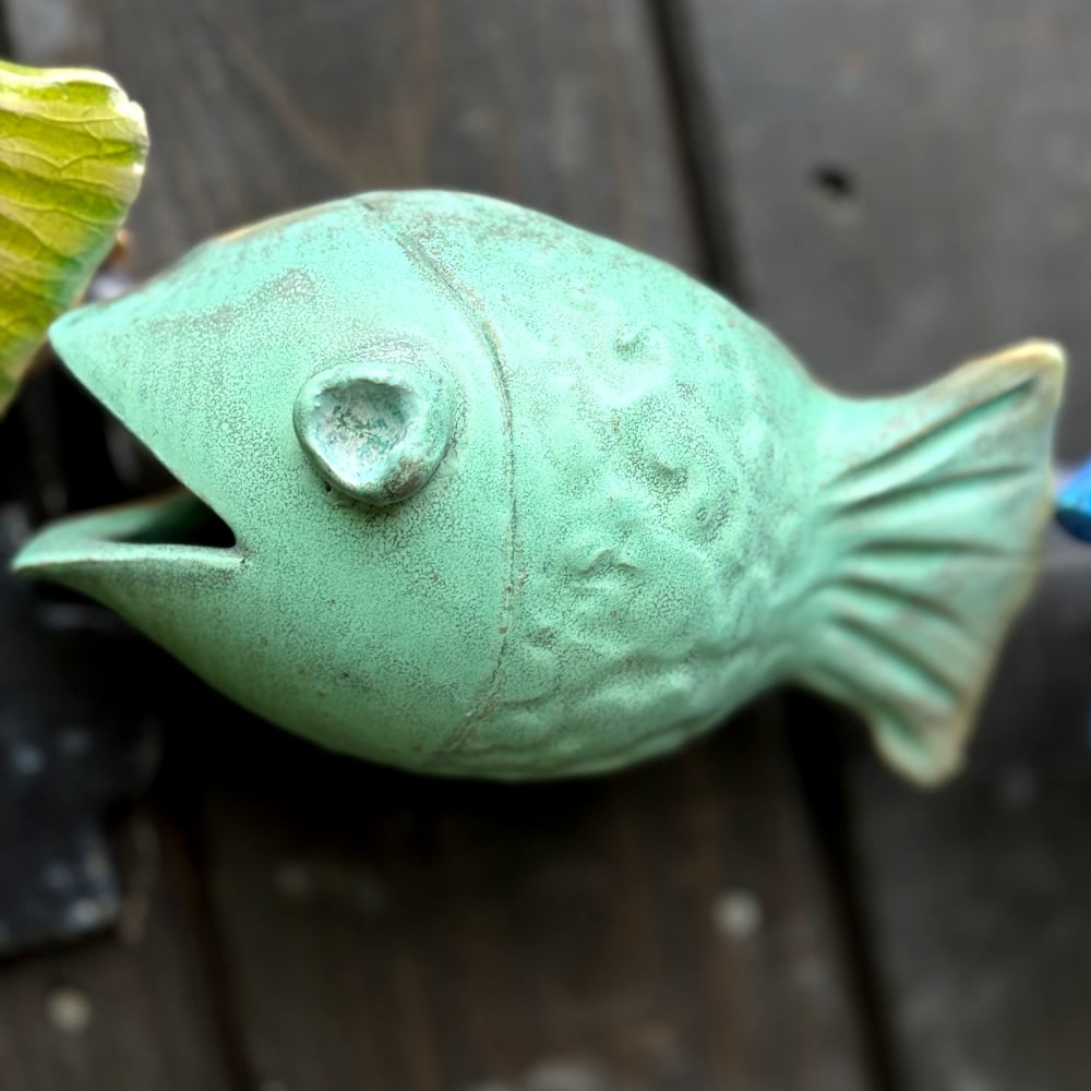 Blue fish as part of the fish-catcher; Wall hanging art: 5 ceramic fish assembled on a metal hoop with decorative scroll