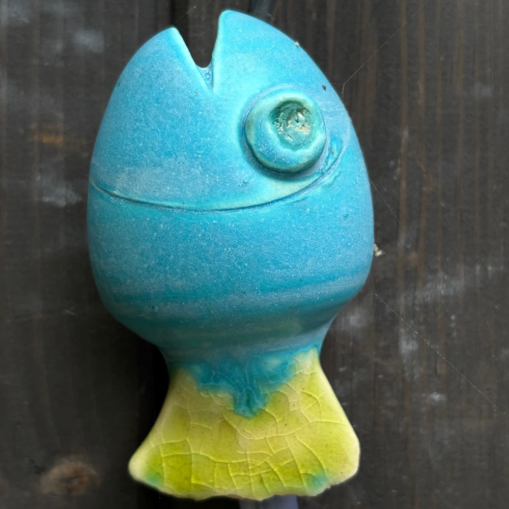 Blue fish as part of the fish-catcher; Wall hanging art: 5 ceramic fish assembled on a metal hoop with decorative scroll