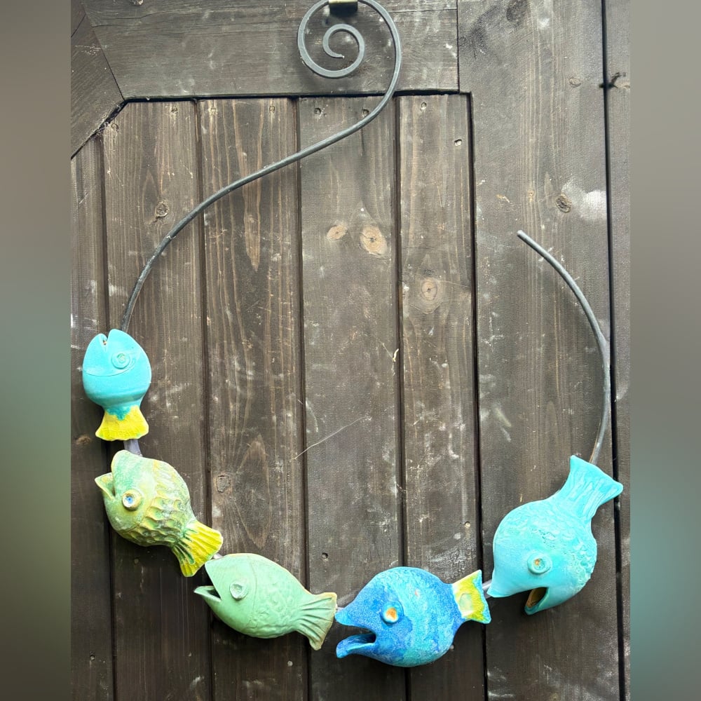 Wall hanging art: The fish catcher, five ceramic fish on a metal hoop with decorative scroll